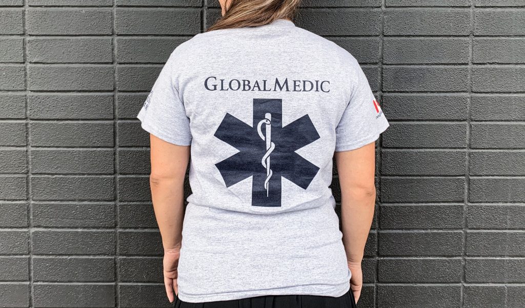 back of a woman wearing a grey GlobalMedic t-shirt
