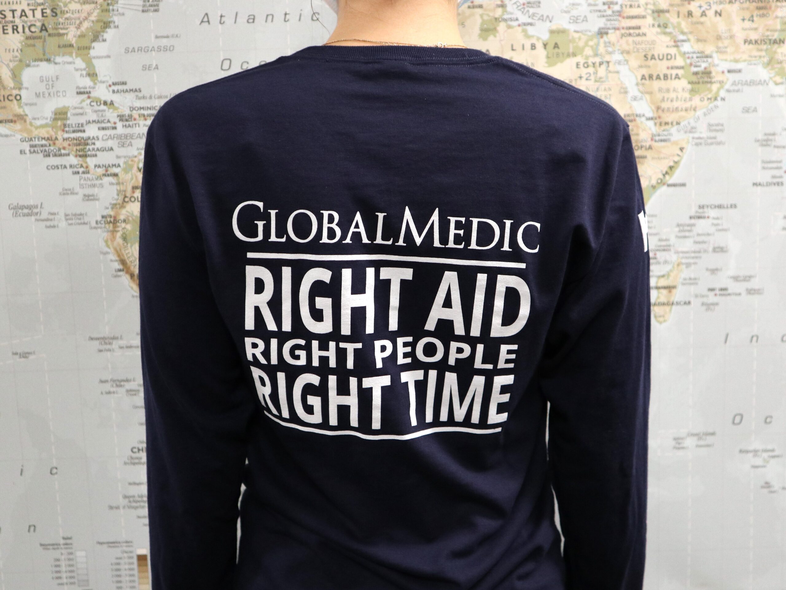 Back of a man wearing a blue GlobalMedic long sleeved shirt