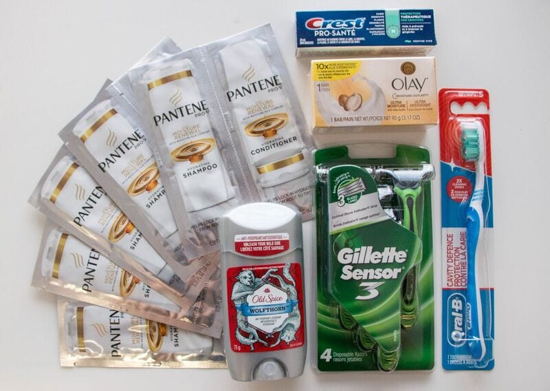 Items in a male hygiene kit, shampoo, conditioner, deodorant, soap, toothpaste, toothbrush, and razors
