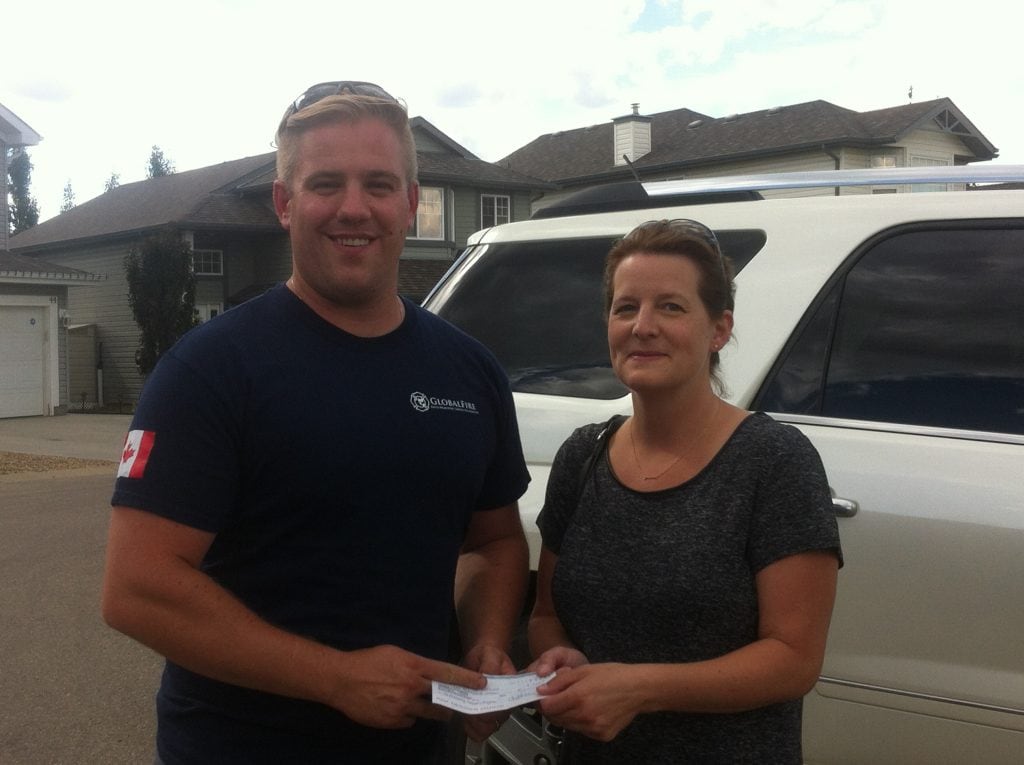 Fort McMurray resident receiving cash transfer from GlobalMedic