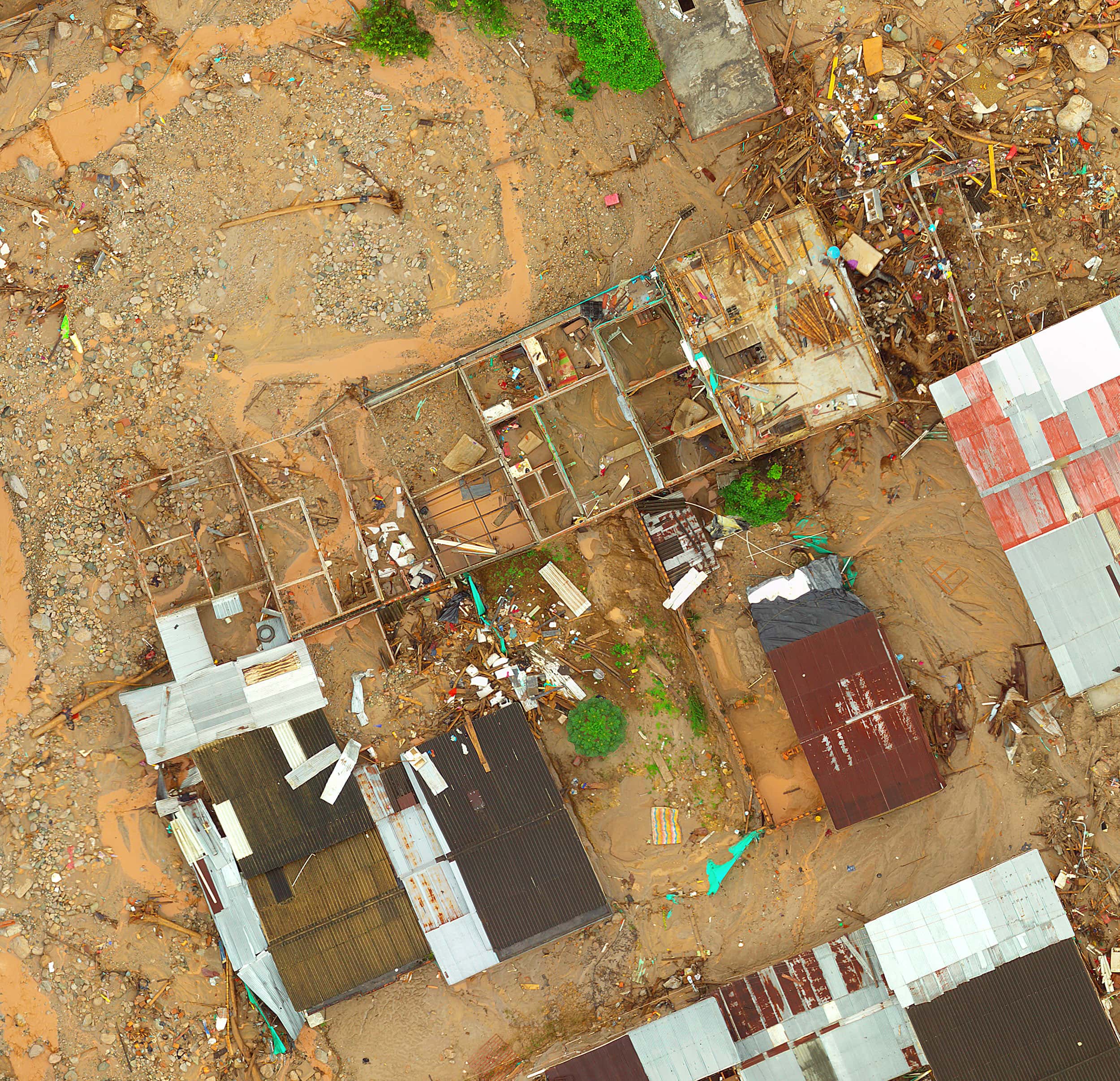 Aerial view of houses damaged by a landslide and surrounded with debris