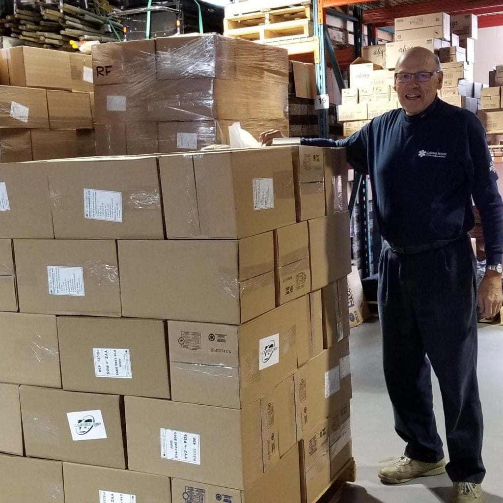 A man standing next to a stack of boxes
