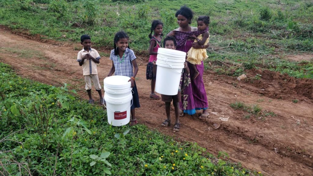 A group of children holding household water purification units