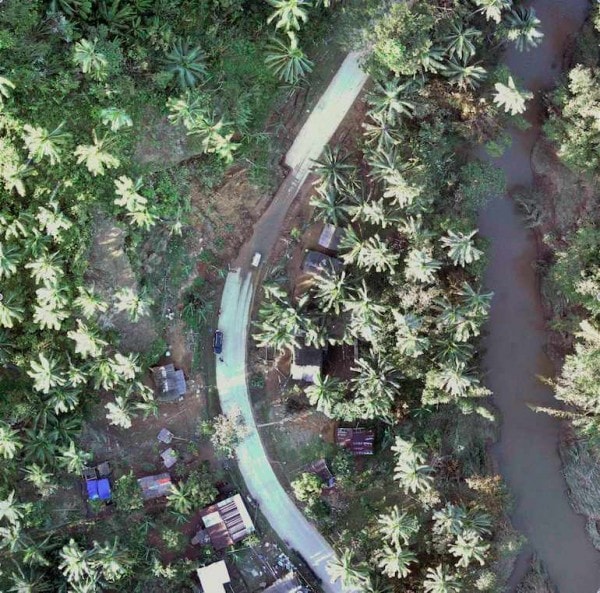 Aerial view of a damaged stretch of road in a forest