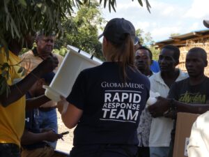 A GlobalMedic staff member demonstrating how to assemble a Rainfresh Family Emergency Kit to a group of people